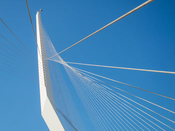 Low angle view of suspension bridge against clear blue sky