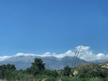 Scenic view of mountains against blue sky