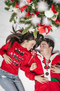 High angle view of couple lying on floor at home during christmas