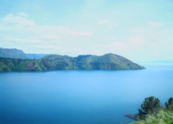 Scenic view of sea and mountains against sky