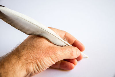 Close-up of man holding hands over white background