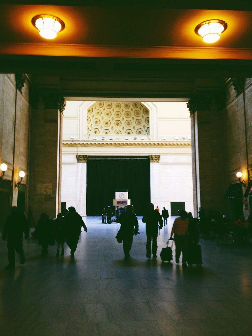 REAR VIEW OF PEOPLE WALKING IN BUILDING