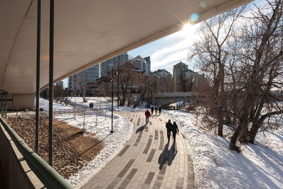 People walking along a pedestrian track in downtown calgary on a sunny winter day