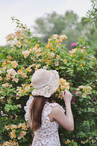 Woman standing by flowering plants