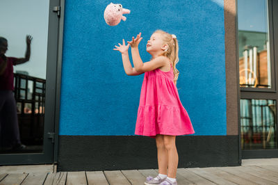 Full length of woman standing against wall