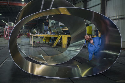 Worker examining metal in factory