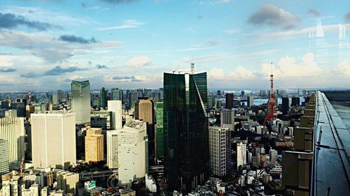 View of cityscape against cloudy sky