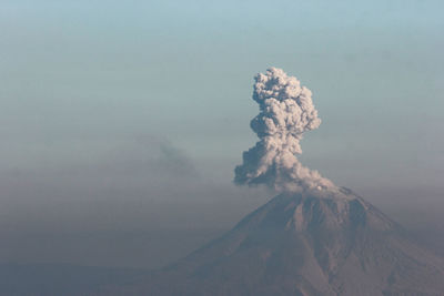 Smoke emitting from volcanic mountain against sky