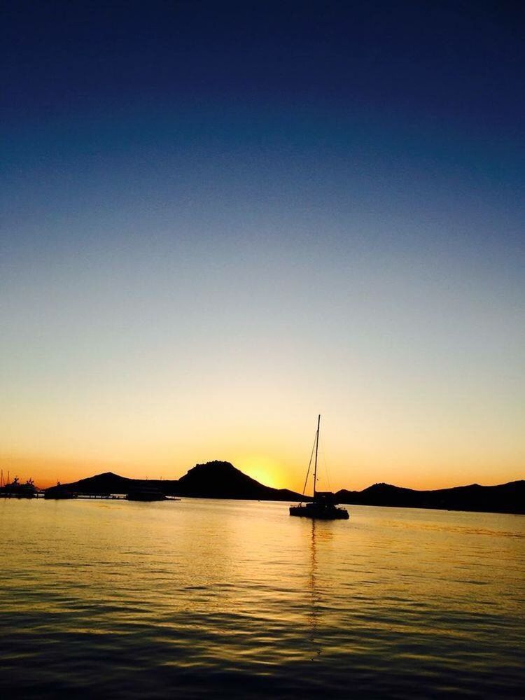 SILHOUETTE SAILBOAT IN SEA AGAINST CLEAR SKY