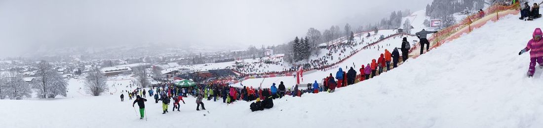 Panoramic view of people on snow covered land