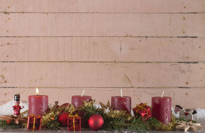 Close-up of candles with christmas decorations on table