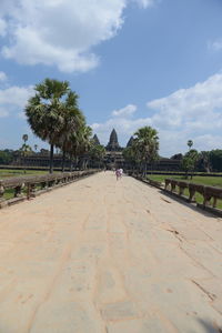 People walking on footpath against sky