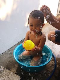 High angle view of man bathing baby girl