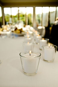 Close-up of illuminated tea light candle on table in restaurant