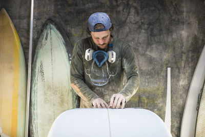 Surfboard shaper measuring a new design