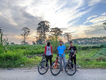 Rear view of people riding bicycle against sky