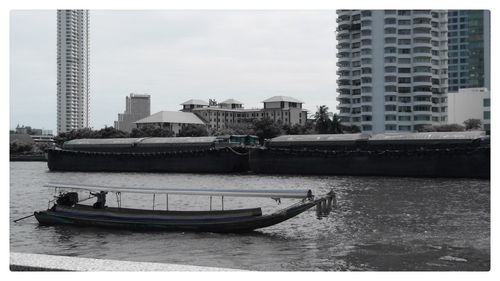 Boats in river with buildings in background