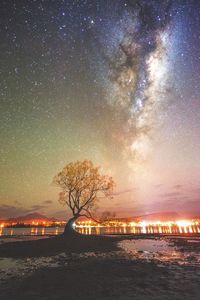 Illuminated city against star field at night