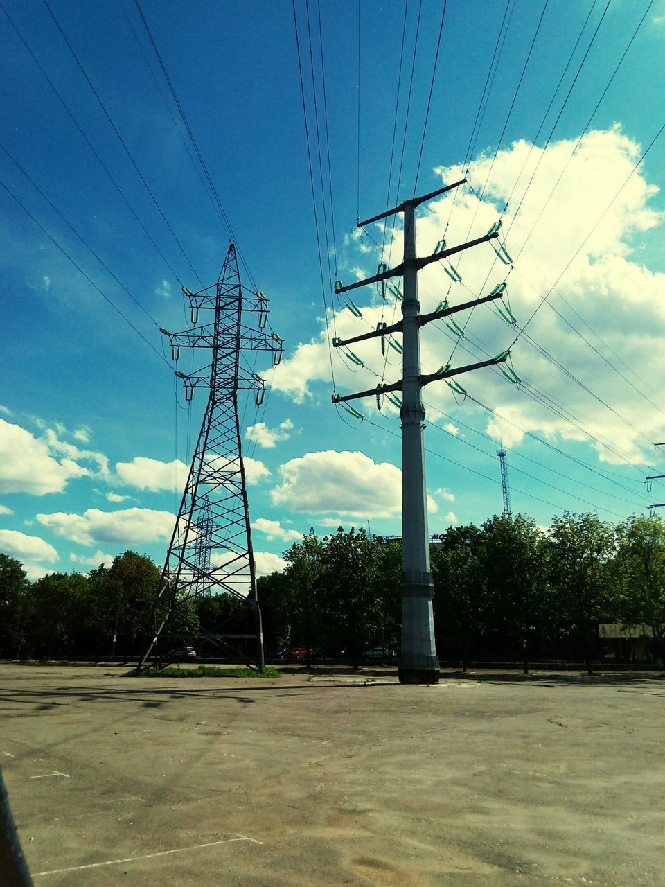 sky, power line, electricity pylon, power supply, electricity, cloud - sky, blue, low angle view, tree, cable, cloud, power cable, day, outdoors, cloudy, no people, nature, pole, tranquility, landscape