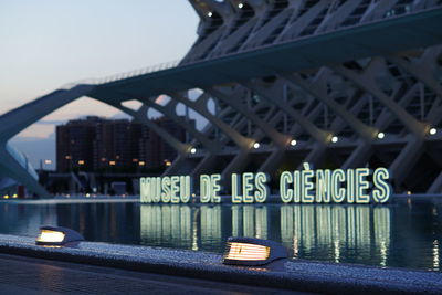 Illuminated bridge over river in city