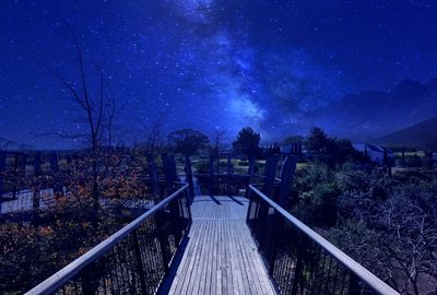 Footbridge against sky at night