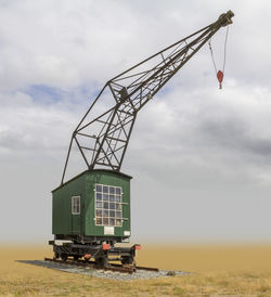 Crane at construction site against sky