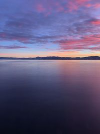 Scenic view of sea against dramatic sky during sunset