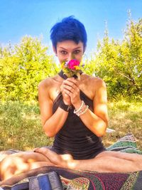 Young woman sitting on grassy field