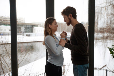 Side view of couple standing by railing