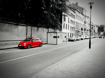 Cars on road against sky in city