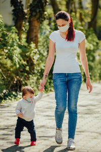 Full length of mother and daughter in hands