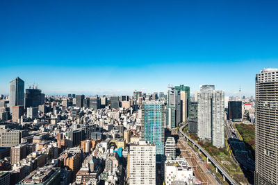 Aerial view of modern buildings against clear blue sky