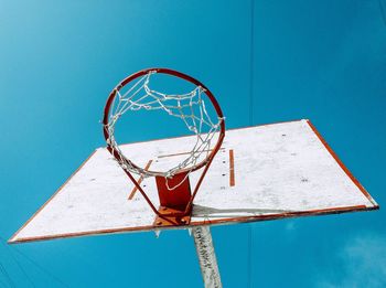 Low angle view of basketball hoop against blue sky