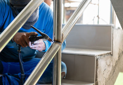 Worker argon welding rail in building site.