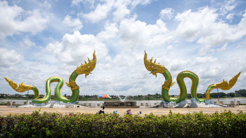 View of statue in park against cloudy sky