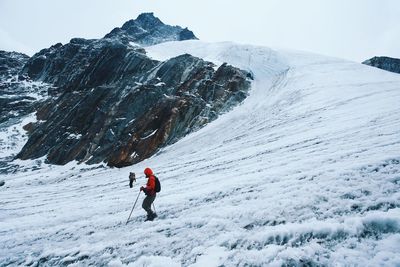 Tourists walking on snow covered mountain