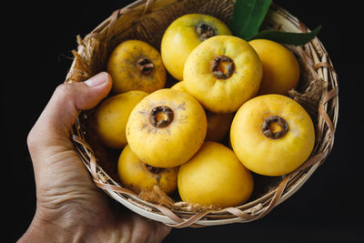 Close-up of hand holding fruits in basket