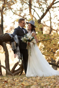 Low section of bride holding bouquet