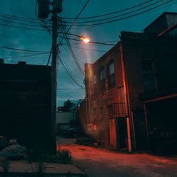 Street amidst buildings against sky at night