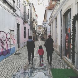 Rear view of men on sidewalk in city