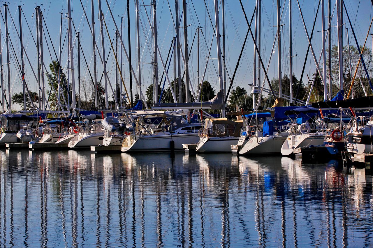 SAILBOATS MOORED IN HARBOR