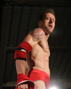 Portrait of shirtless man standing in boxing rink