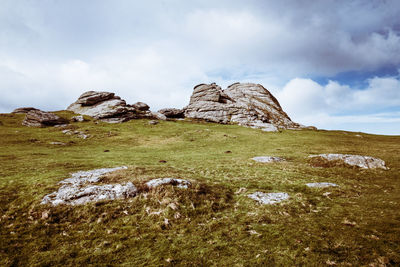 Rocks on field against sky