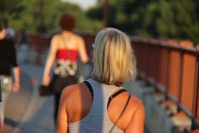 Rear view of women on footpath in city