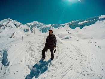 Rear view of man walking on snow covered mountain