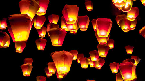 Low angle view of illuminated lanterns hanging in the dark
