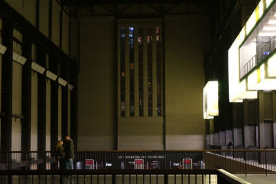 Man standing in illuminated building at night