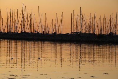 Silhouette sailboats in lake against sky during sunset