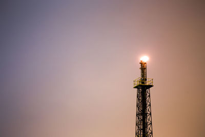 Low angle view of illuminated tower against sky at night