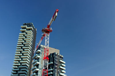 Low angle view of crane against sky